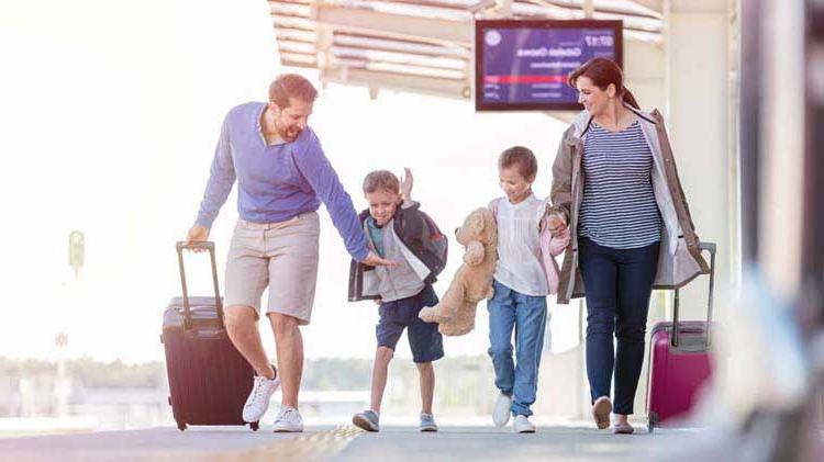 妈妈，爸爸和两个孩子带着行李在机场旅行.